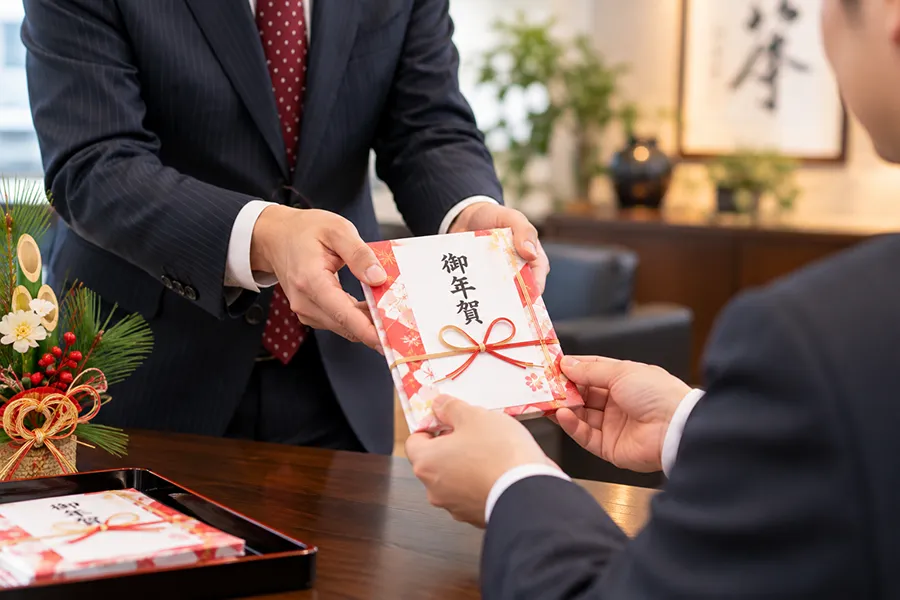 年末年始のご挨拶回りでオリジナルカイロを渡すイメージ
