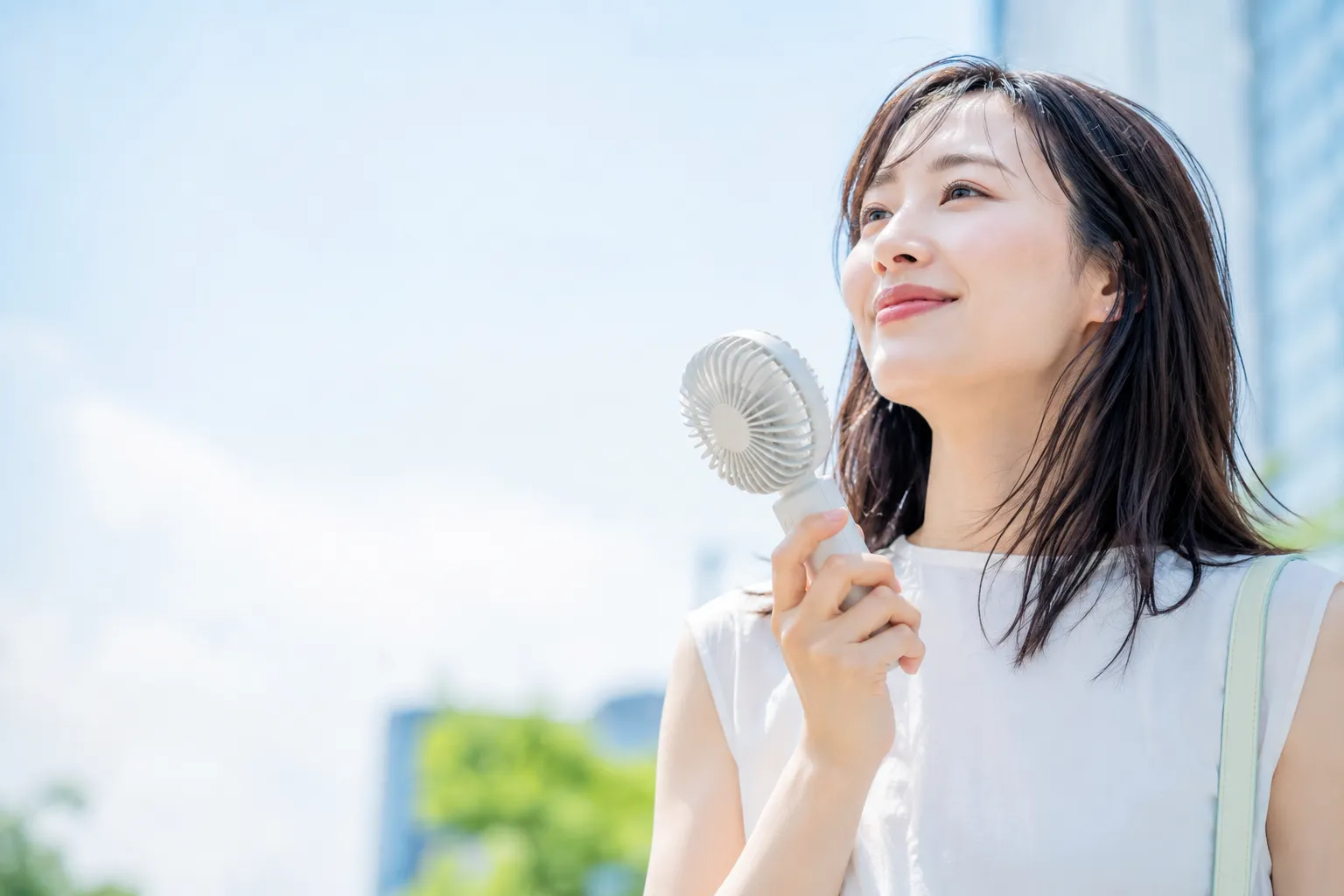 夏の屋外で携帯扇風機として使われるオリジナルハンディファンのノベルティ