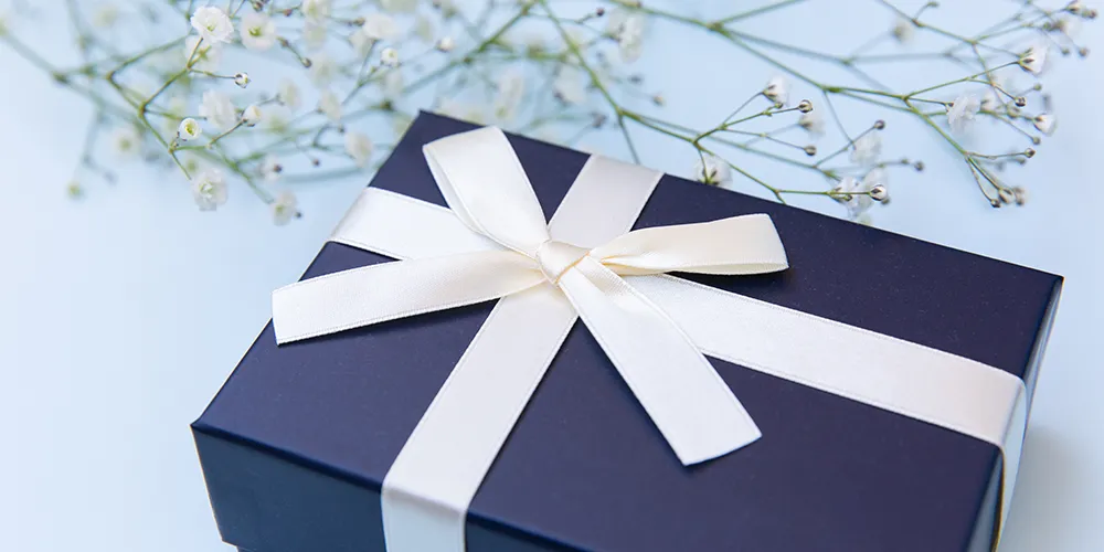 花と上品なギフト箱が並んでいるイメージ。