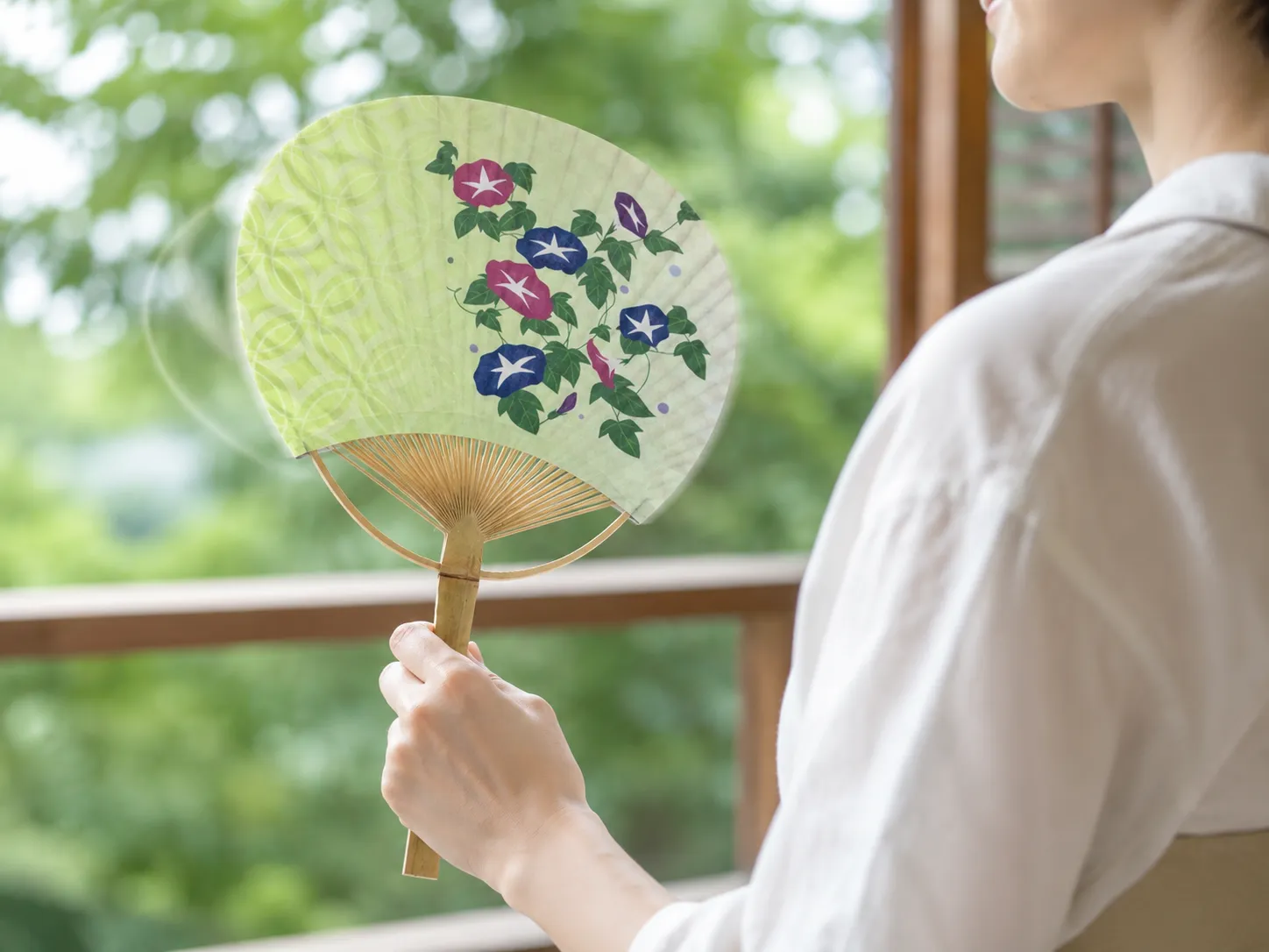 竹うちわを手に持ち、しなりを生かして涼しくあおいでいるシーン